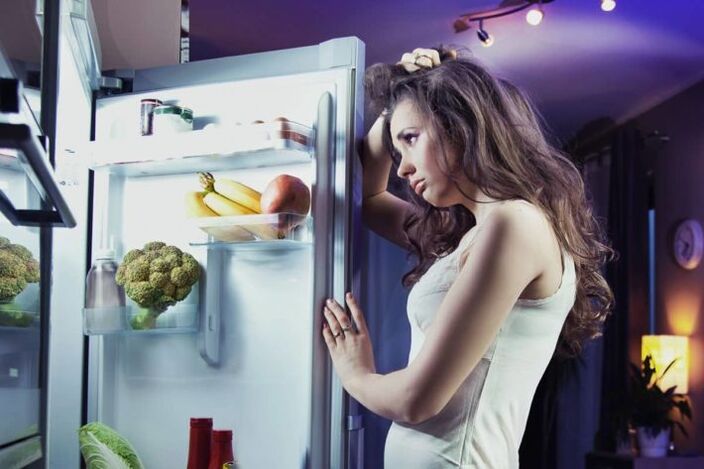 fille au réfrigérateur tout en suivant son régime préféré