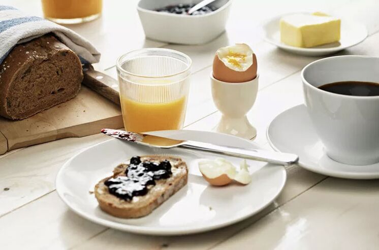 Du pain grillé aux grains entiers, un œuf et une tasse de café - petit-déjeuner selon un menu diététique de 1 500 calories